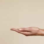 Close-up of an open hand reaching out isolated on a neutral background, symbolizing offering or receiving.
